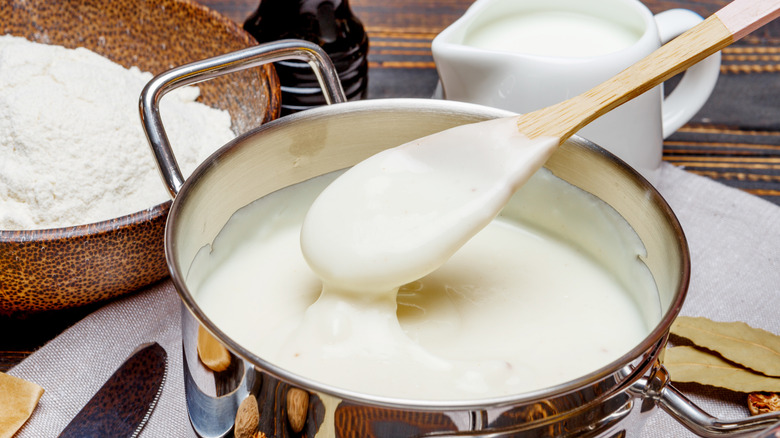 Closeup of Béchamel σε μια κατσαρόλα με ξύλινο κουτάλι